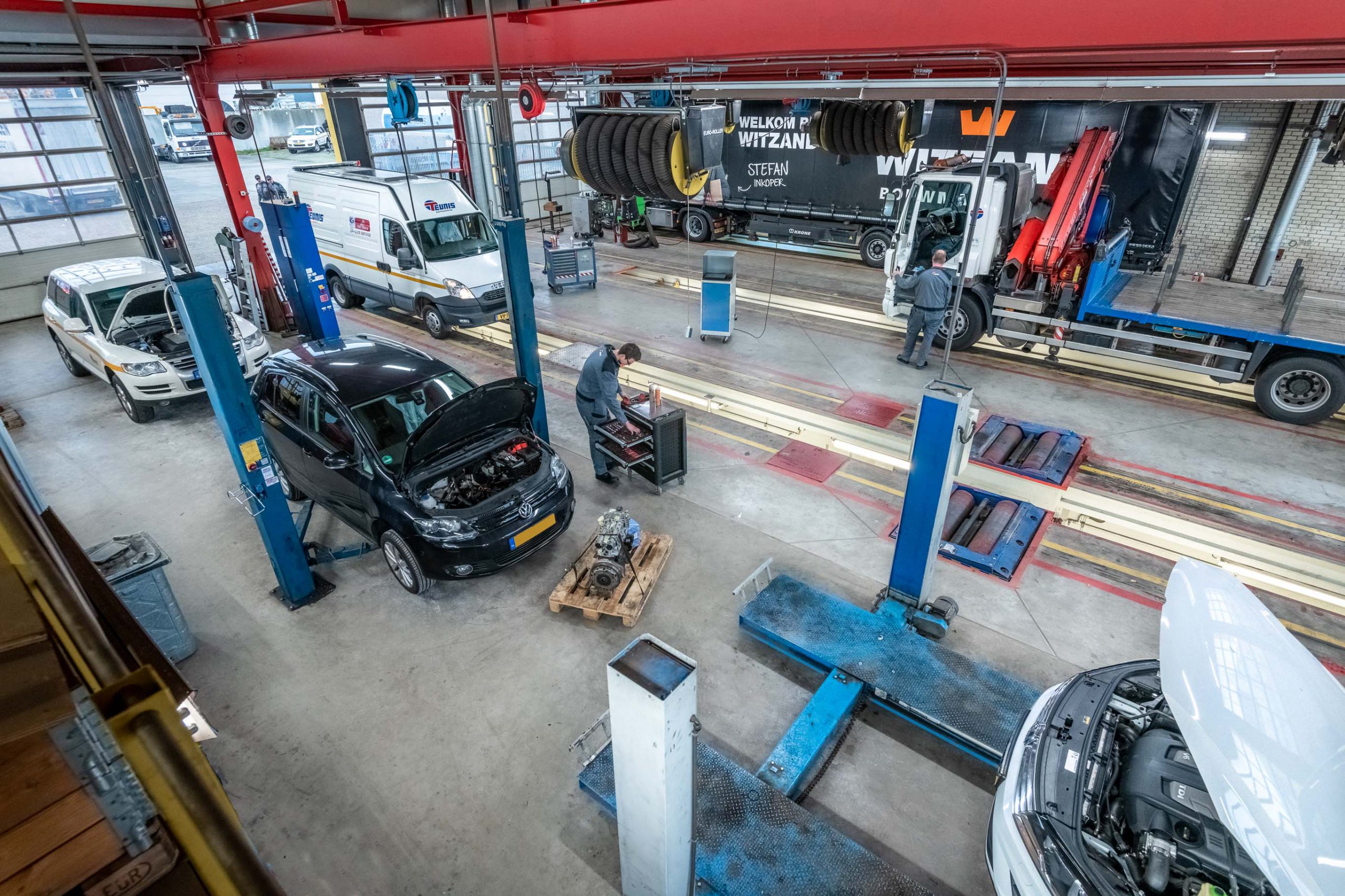 werkplaats met auto's vrachtwagens en werkbussen van bovenaf